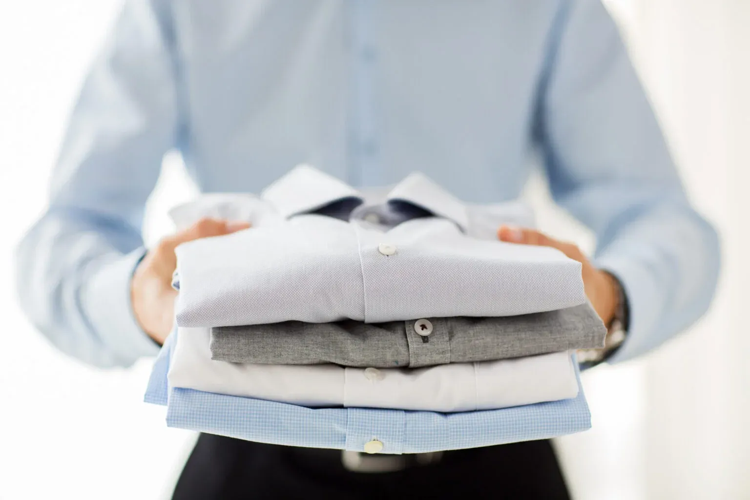 Commercial laundry service for businesses in Kuwait — folded shirts and linen